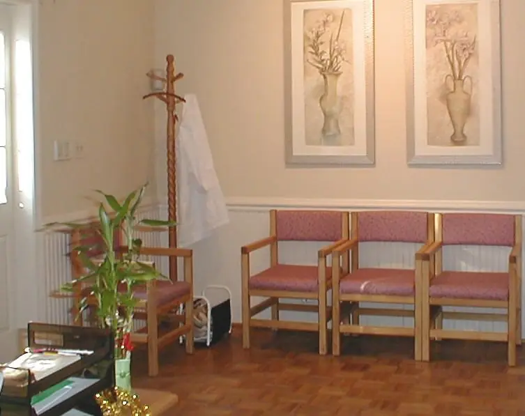 Waiting room at Acuherb Clinic with upholstered chairs, a wood floor, a coat rack and a plant